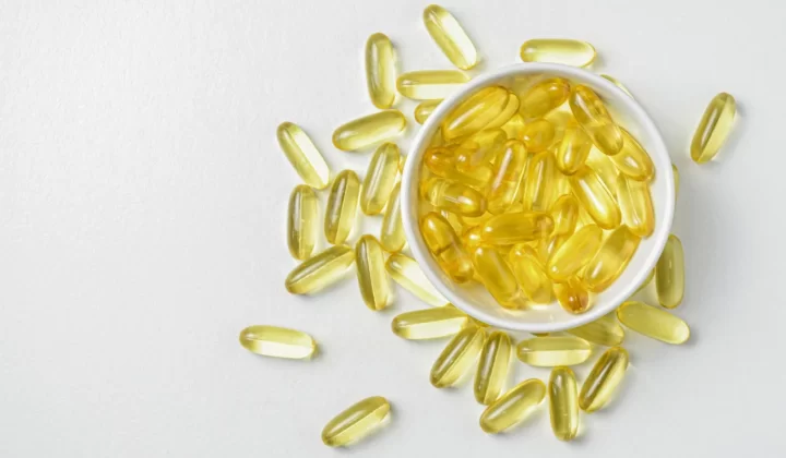 陶瓷碗中的Omega-3鱼油胶囊高角度特写,白色背景