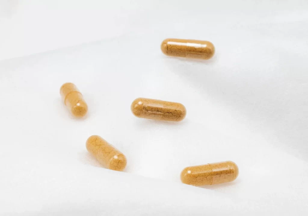 棕色胶囊放在白色表面特写,强调健康和补充剂