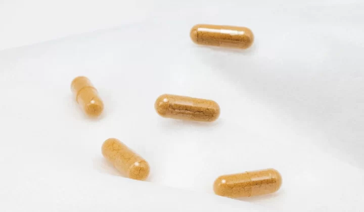棕色胶囊放在白色表面特写,强调健康和补充剂