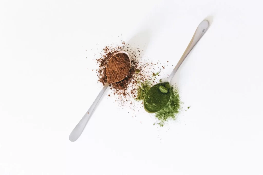 勺子装可可粉和抹茶粉特写,白色表面食品健康主题