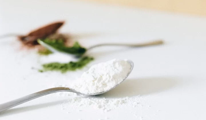 各种彩色粉末放在勺子上特写,背景虚化