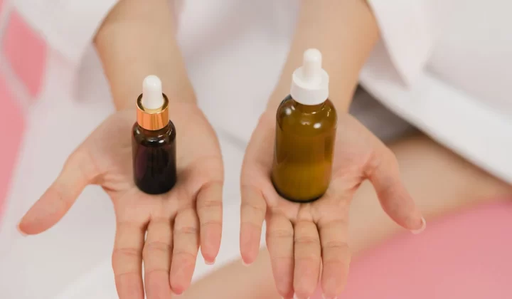 双手持有两个滴管精华瓶特写