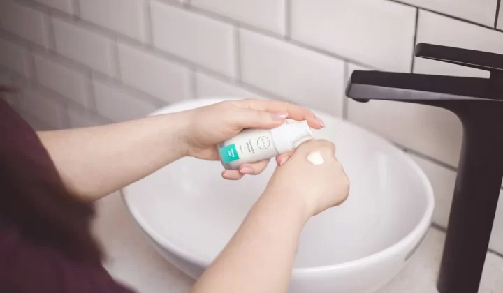 person holding white and blue plastic bottle