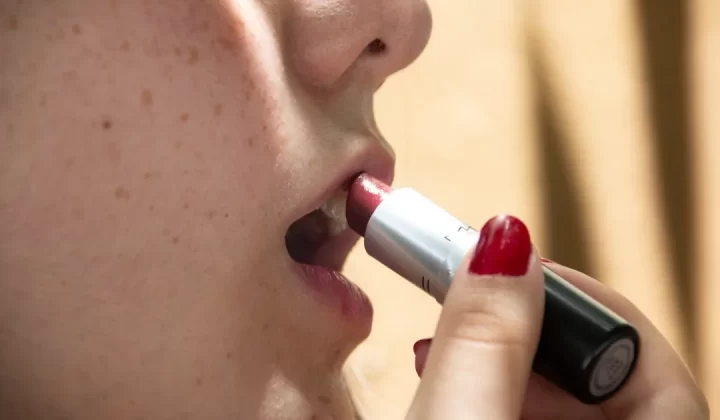woman putting lipstick on her lips