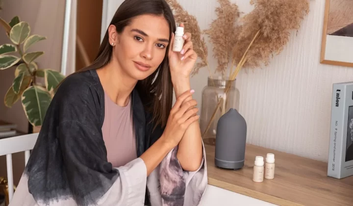a woman sitting on a chair holding a bottle of cream