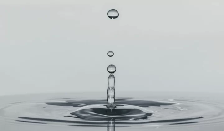 a drop of water falling into a body of water
