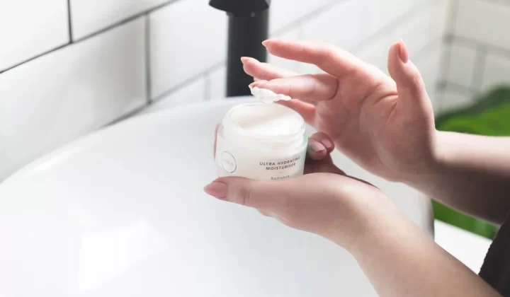 person holding white and black plastic bottle