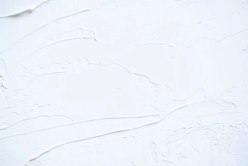 a close up of a white wall with peeling paint