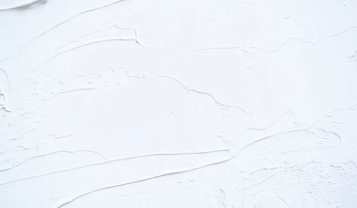 a close up of a white wall with peeling paint