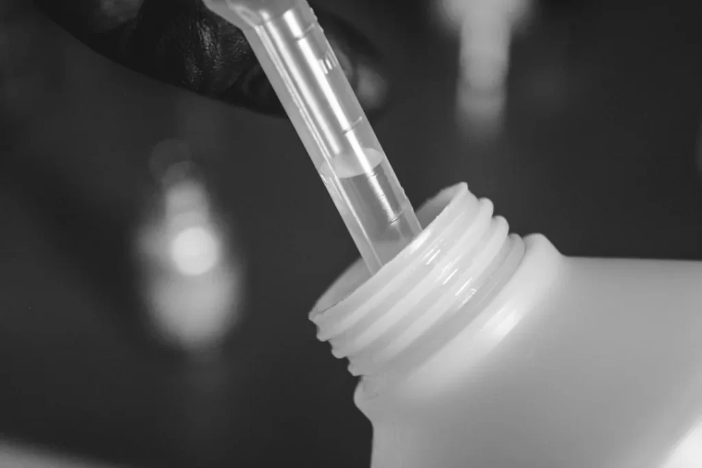 a person is holding a plastic bottle with a straw in it