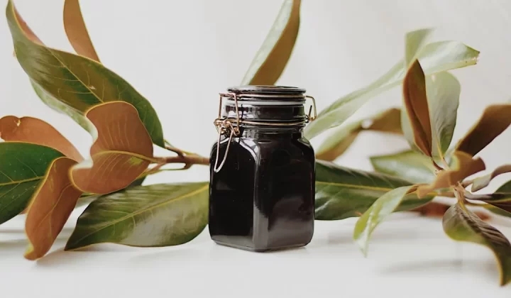 a jar of black liquid sitting on top of a table
