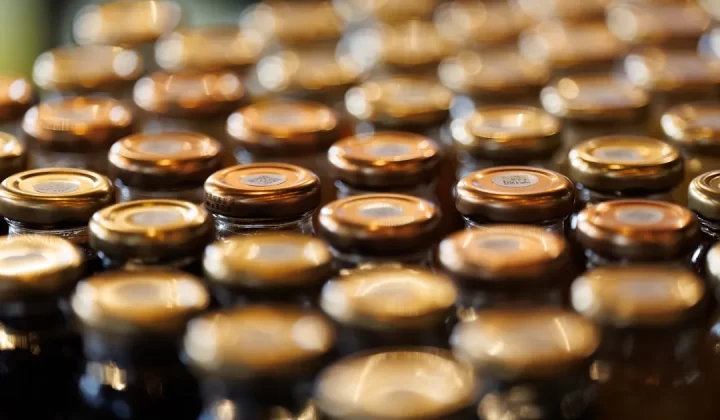 Rows of golden bottle caps in soft focus