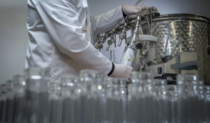 person in white chef uniform holding clear glass bottle
