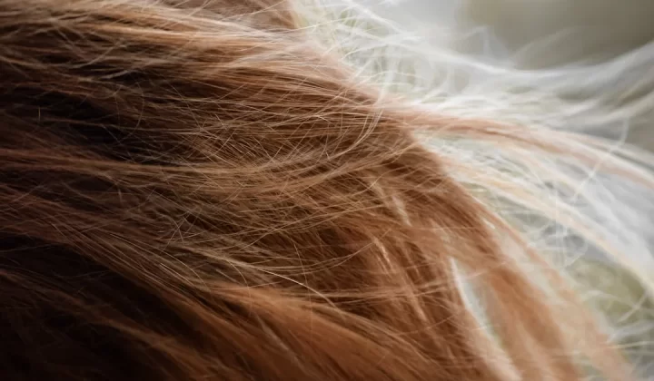 brown hair on white textile