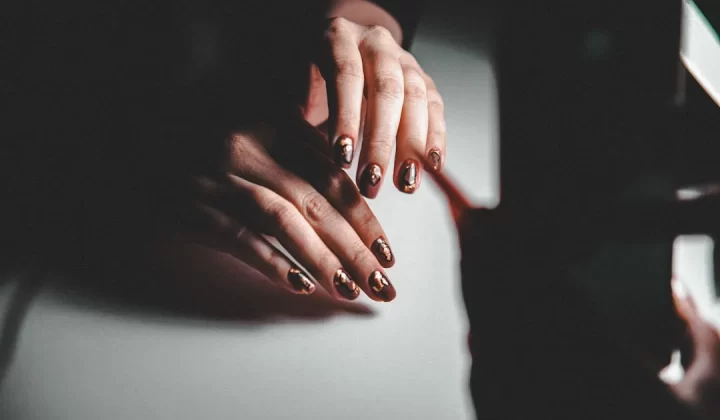 A woman's hands resting on a piano
