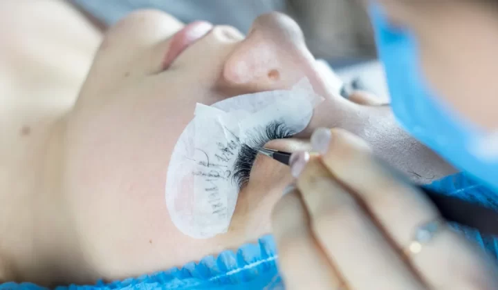 a woman getting her eyelashes done by a professional makeup artist