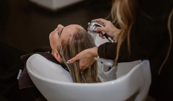 a woman getting her hair cut by a hair stylist