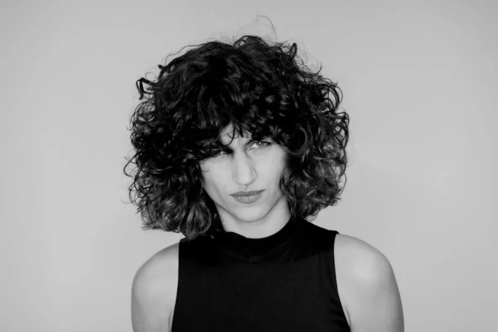 a black and white photo of a woman with curly hair