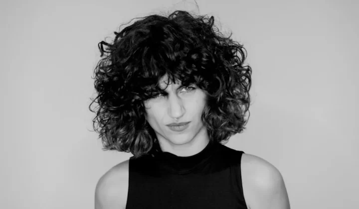 a black and white photo of a woman with curly hair