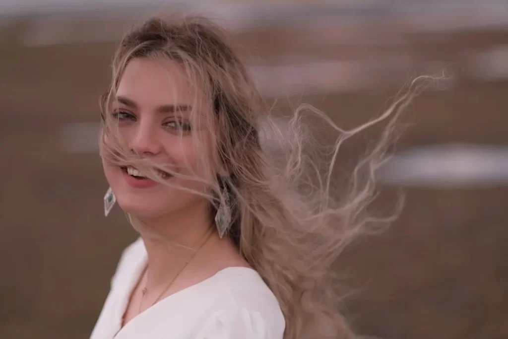 a woman with long hair is smiling and looking at the camera