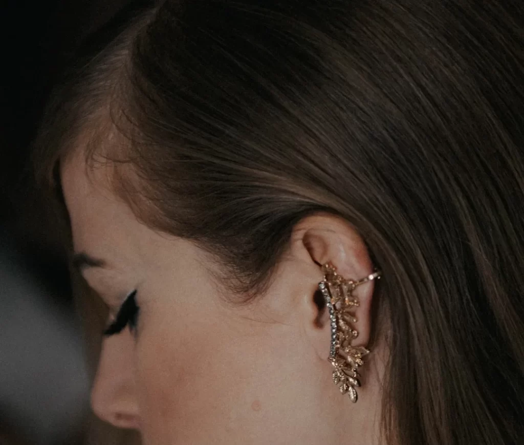 a close up of a person wearing a pair of earrings