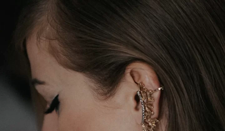 a close up of a person wearing a pair of earrings