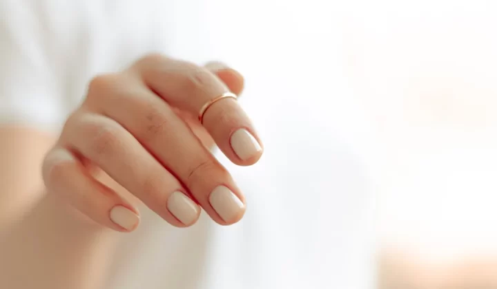 persons hand with white manicure