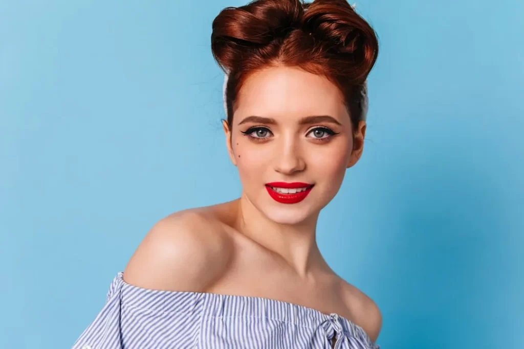 a woman with red lipstick and a bun in her hair