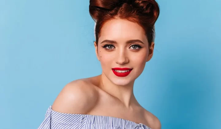a woman with red lipstick and a bun in her hair
