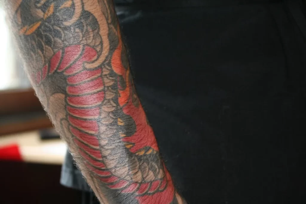 Close-up of a colorful dragon tattoo on an arm