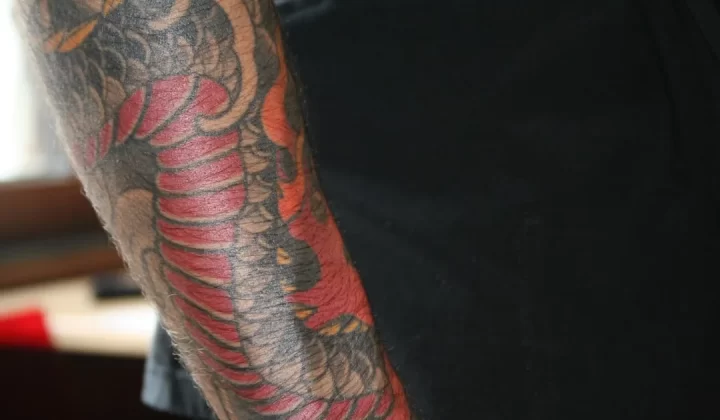Close-up of a colorful dragon tattoo on an arm