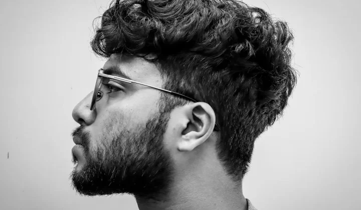 Man with glasses and curly hair in profile.