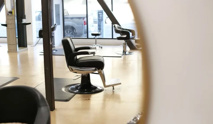 black leather barber chair near glass window