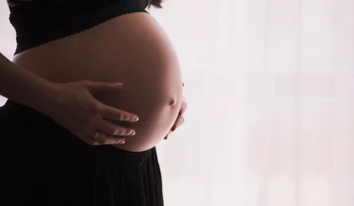 pregnant woman cradling her belly
