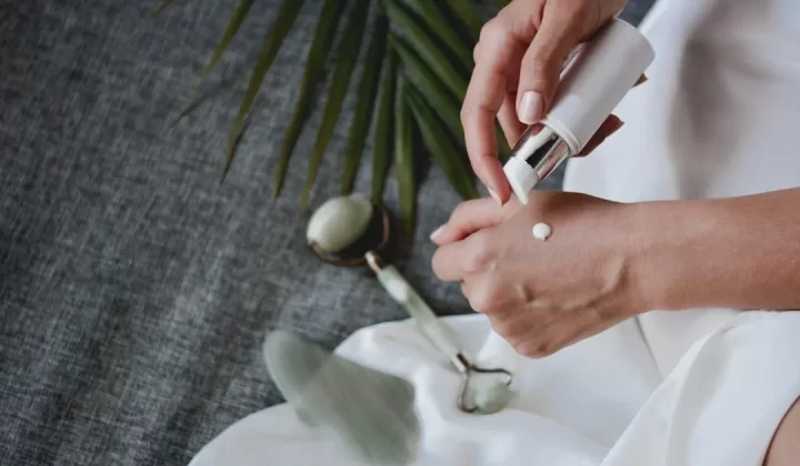 person holding white plastic bottle pouring white liquid on white ceramic mug