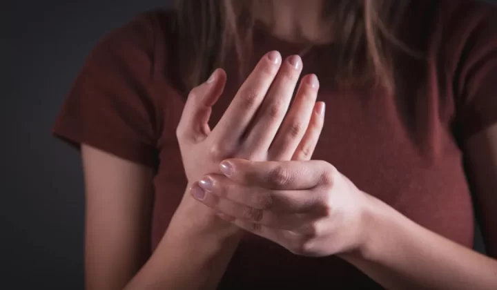 Woman holding her hand with pain.