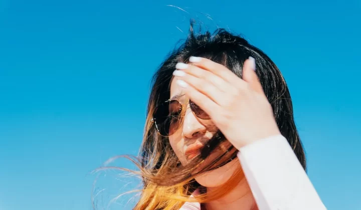Woman shields her eyes from the bright sun.