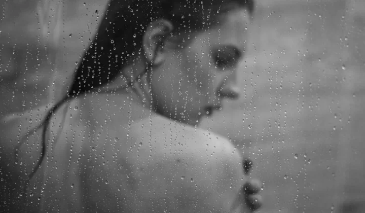 a black and white photo of a woman in the rain