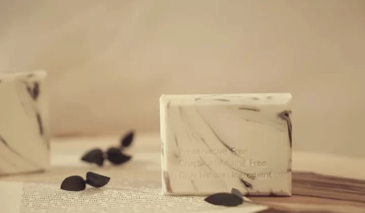 a white box with a label on it next to a pile of black pebbles