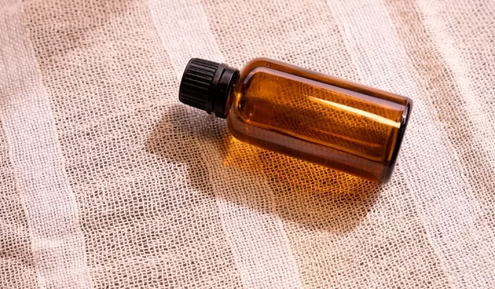 a bottle of essential oil sitting on a cloth