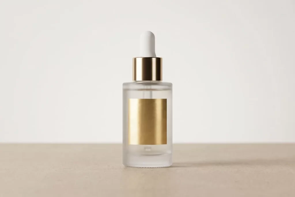 Clear glass dropper bottle with gold cap and label.