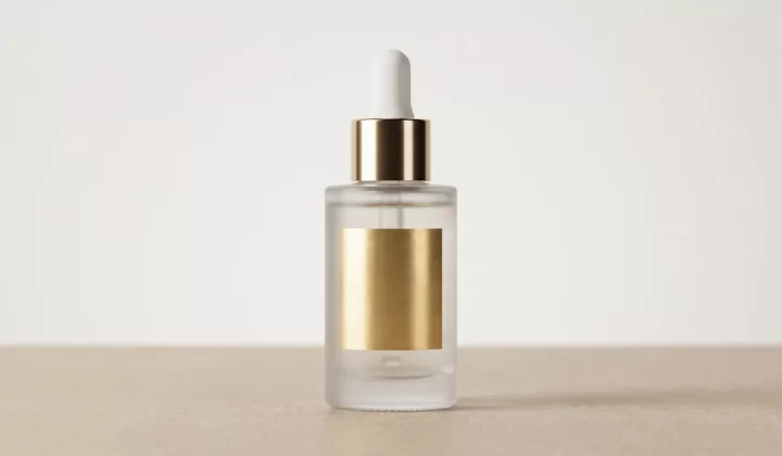 Clear glass dropper bottle with gold cap and label.
