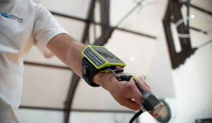 Man wearing a device on his arm with a cable.