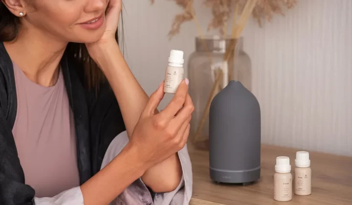 a woman sitting on a table holding a bottle of lotion