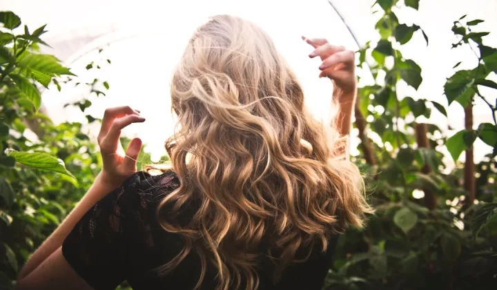 blonde haired woman in black top surrounded by tall plants