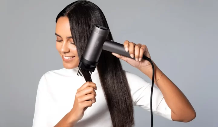 a woman blow drying her hair with a hair dryer