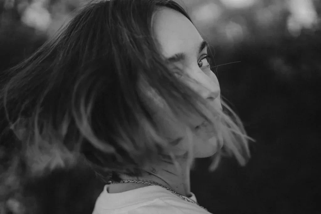 a black and white photo of a person with long hair