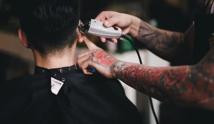 person using white hair clipper