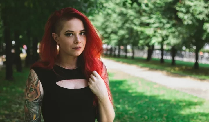 woman in black tank top standing near green grass field during daytime