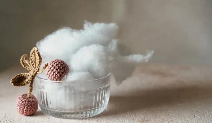 a glass bowl filled with cotton next to a cotton ball
